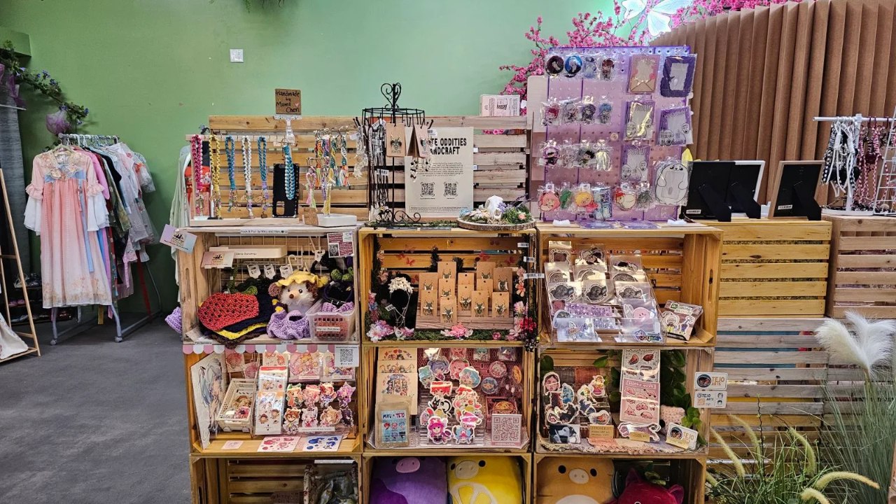 Handmade jewelry, stickers and crochet gifts displayed in wooden crates at Happy Humble Hub