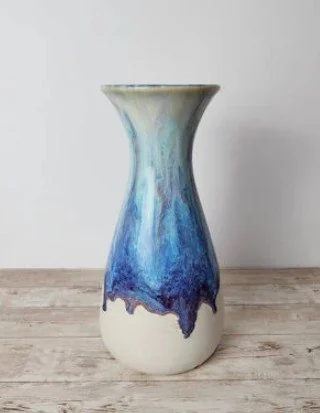 Handmade white ceramic vase with flowing blue glaze