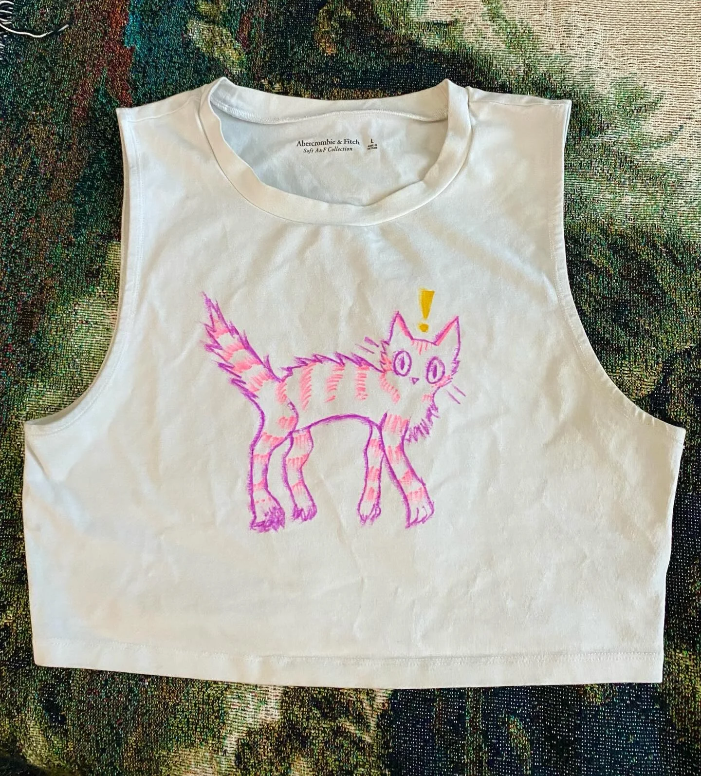 Cream sleeveless top with a pink creature illustration