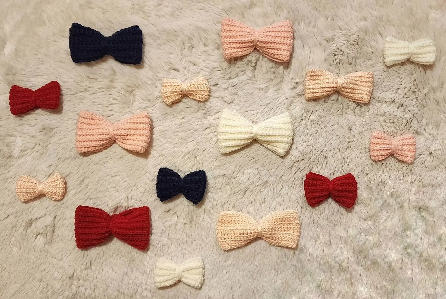 Crocheted bow accessories in cream, pink, red, and navy