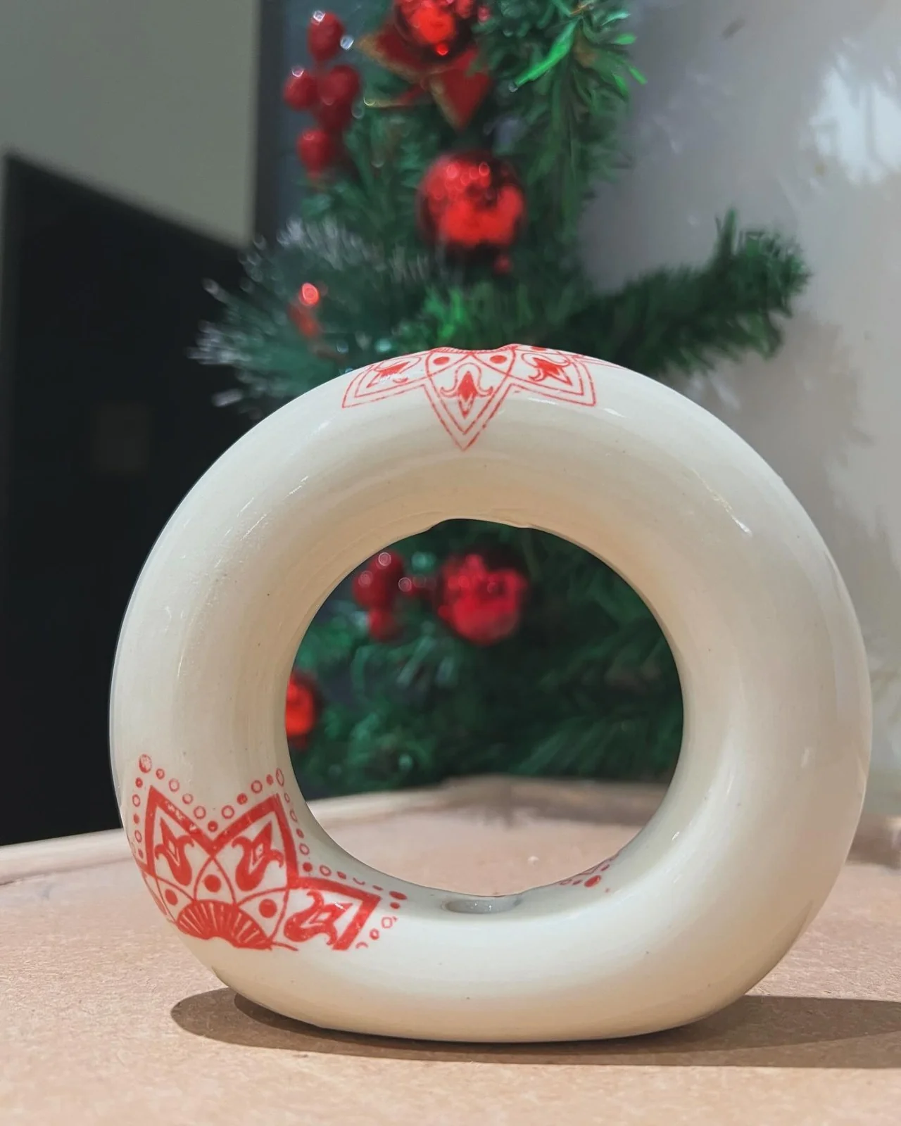 White ceramic donut vase with red holiday decoration